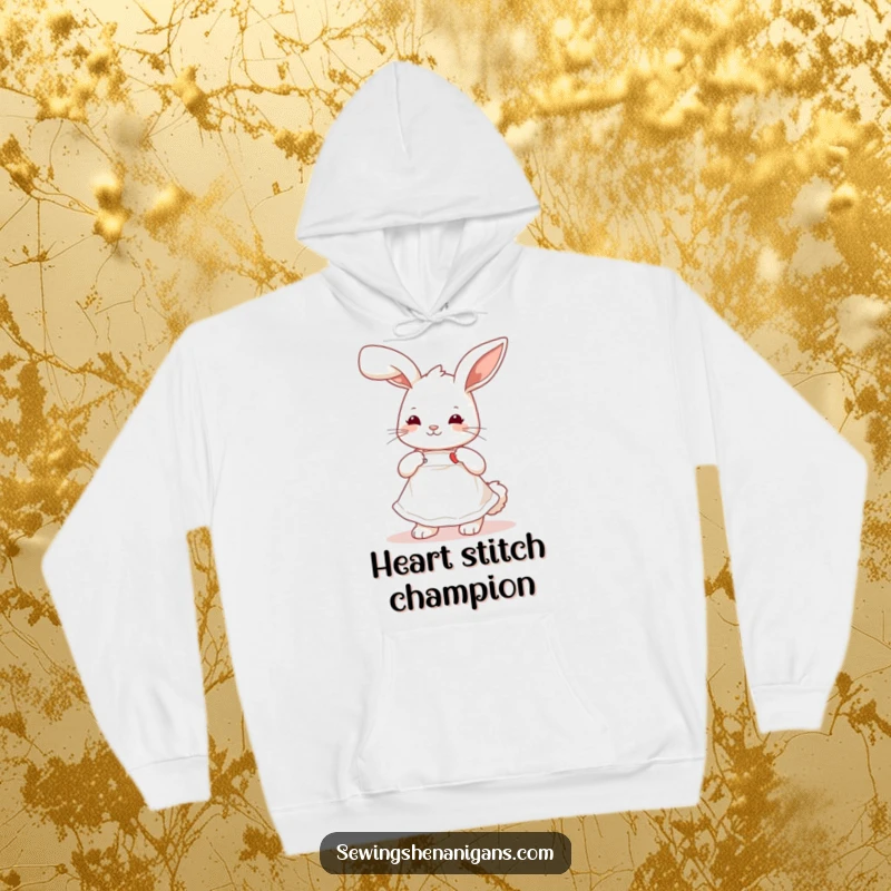 Funny playful bunny wearing a cute apron, stitching a tiny heart, a comfortable and humorous hoodie for crafters.