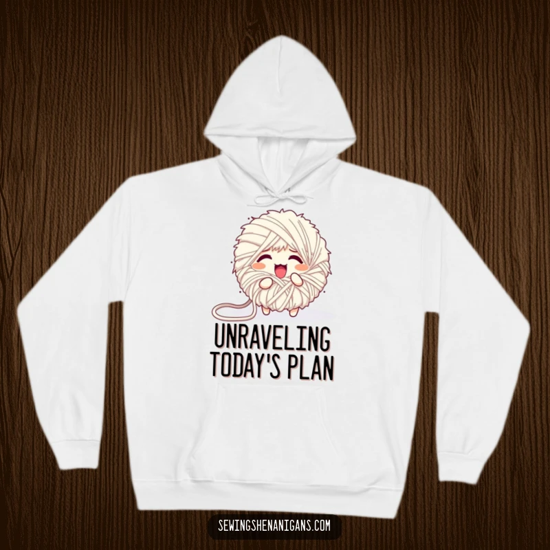 Funny hoodie featuring a fluffy yarn ball character comically unraveling into a mess, offering a cozy and humorous feel.