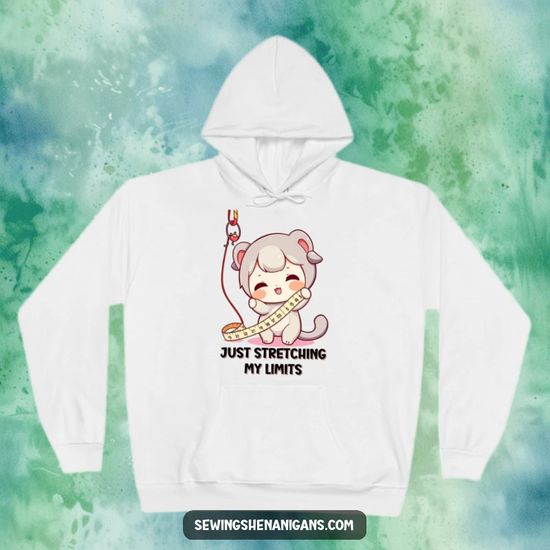 Funny hoodie showing a character playfully swatting a dangling measuring tape, ideal for cozy crafting sessions and humorous moments.