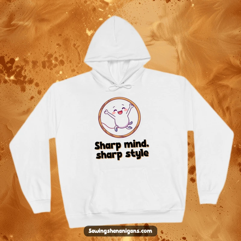 Funny needle character hoodie leaping through a thread hoop, offering comfort and playful humor for crafters and as a funny gift.