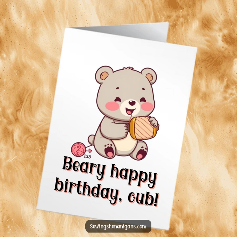 Funny Free Printable Birthday Card: A cheerful bear cub with a thimble enthusiastically hammers a spool, celebrating birthday.