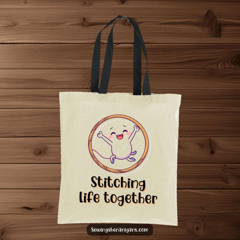 Funny needle character tote bag leaping through a thread hoop, perfect for carrying supplies with playful humor and as a funny gift.